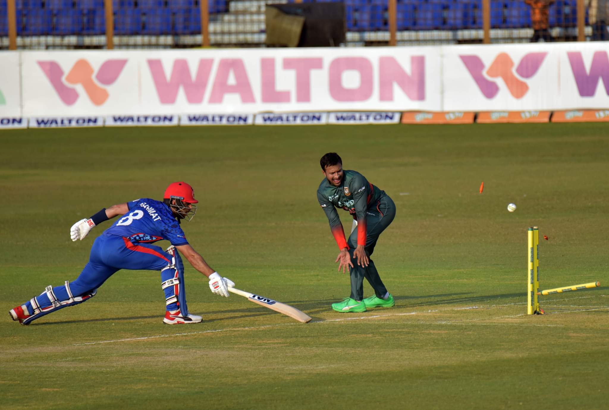 Ball hits the stumps off Najibullah Zadran's bat as Rahmat Shah tries to get back in